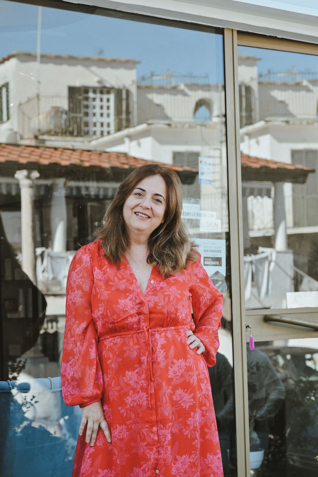 The owner of Encanto smiling in front of the salon